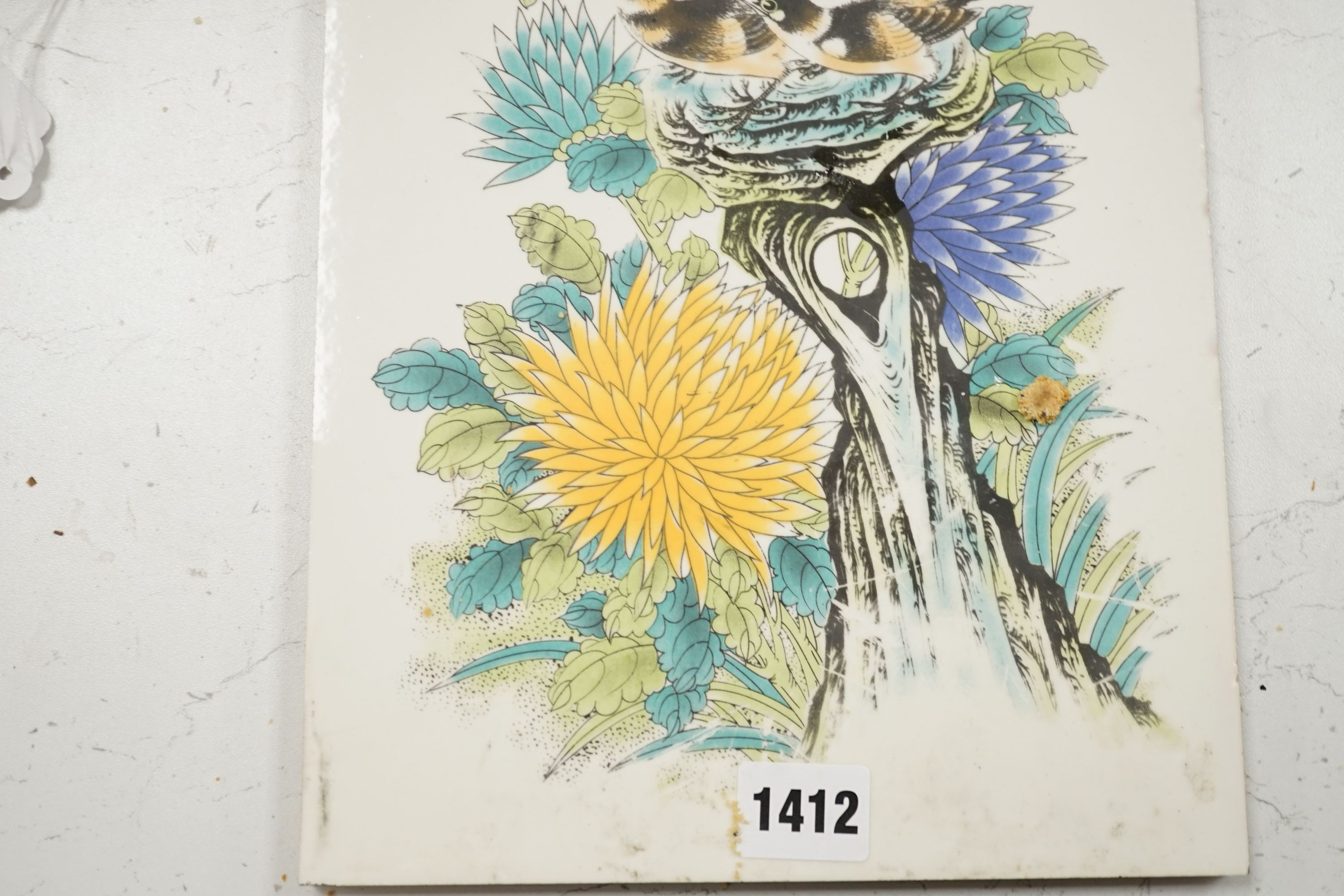 A Chinese enamelled tile, decorated with birds and flowers, 75 cms high x 22 cms wide.